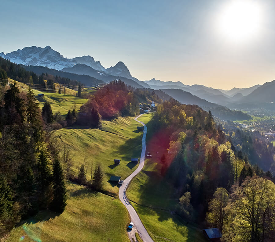 Landstraße schlängelt sich durch Alpenlandschaft